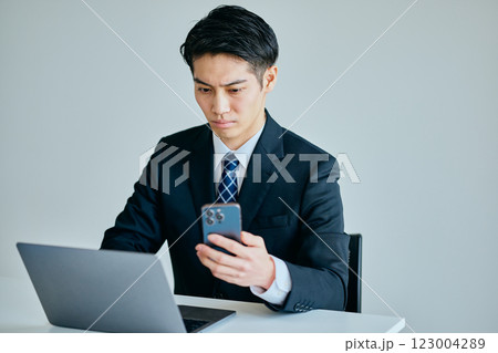 スマホを操作する20代の若い男性 スマホを操作する20代の若い男性 123004289