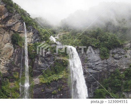 霧深い山々を流れ落ちる滝 123004551