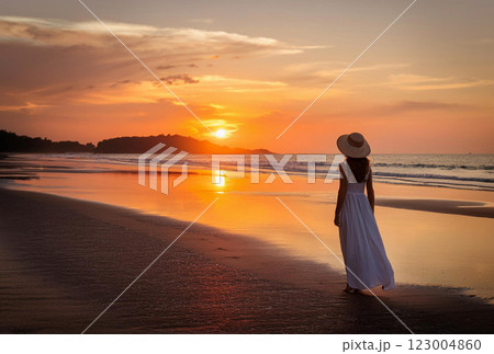 夕日の中を歩く女性 123004860