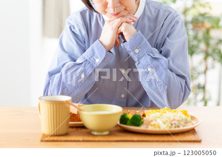 洋食の朝食を前に悩むミドル女性 123005050