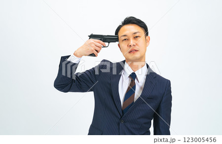 こめかみに拳銃をあてるミドルエイジ男性ビジネスパーソン 123005456