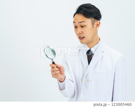 ルーペで何かを発見した白衣を着たミドルエイジ男性医師・研究者 ルーペで何かを発見した白衣を着たミドルエイジ男性医師・研究者 123005460