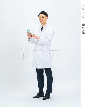 スマホを使う白衣を着たミドルエイジ男性医師・研究者の全身写真 スマホを使う白衣を着たミドルエイジ男性医師・研究者の全身写真 123005466