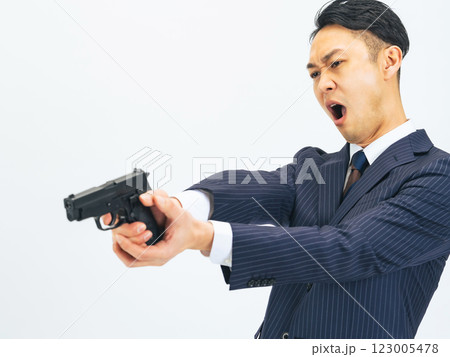拳銃を構えて叫ぶスーツを着たミドルエイジ男性 123005478