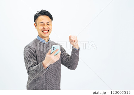 スマホを見ながらガッツポーズするミドルエイジ男性 スマホを見ながらガッツポーズするミドルエイジ男性 123005513