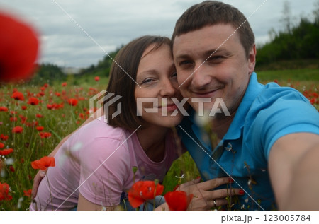 Young couple among blooming red poppies Young couple among blooming red poppies 123005784