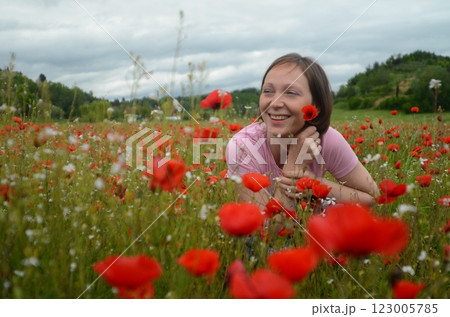 Beautiful young woman in a blooming poppy field 123005785