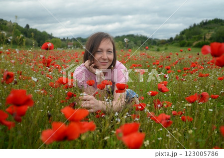 Beautiful young woman in a blooming poppy field Beautiful young woman in a blooming poppy field 123005786