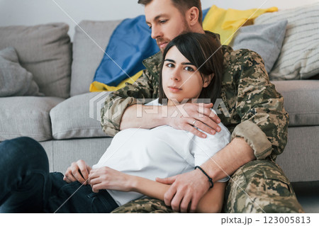 Defending Ukraine. Soldier in uniform is at home with his wife 123005813