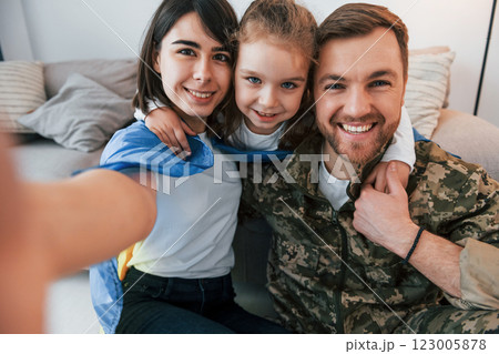 Making selfie. Soldier in uniform is at home with his wife and daughter Making selfie. Soldier in uniform is at home with his wife and daughter 123005878