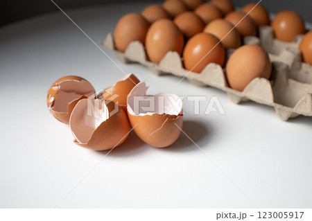 Eggshells and eggs in a paper tray on white table 123005917