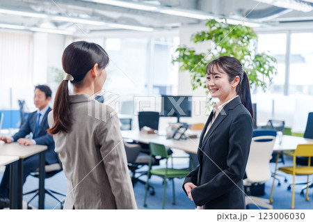 先輩社員にオフィスを案内してもらうフレッシュな女性 123006030