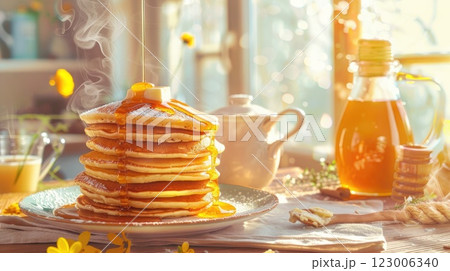 Morning indulgence with stacks of fluffy pancakes drenched in warm syrup next to a cozy sunlit kitchen 123006340