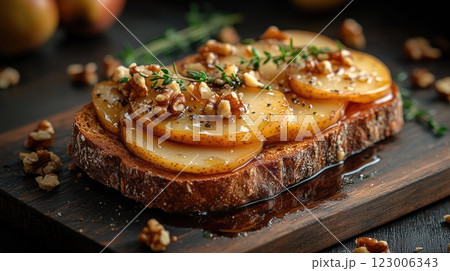 Delicious open-faced toasted bread topped with pears, walnuts, and honey served on a wooden board 123006343