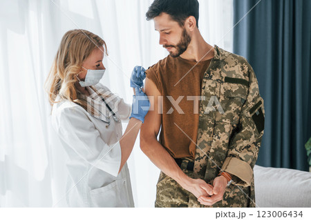 Soldier get vaccinated by female doctor indoors Soldier get vaccinated by female doctor indoors 123006434