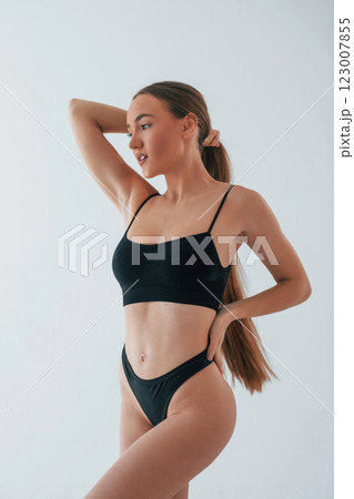 Beautiful female with brown hair. Woman in underwear with slim body type is posing in the studio Beautiful female with brown hair. Woman in underwear with slim body type is posing in the studio 123007855