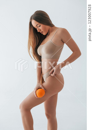 Healthy eating. Fruit in hand. Woman in underwear with slim body type is posing in the studio Healthy eating. Fruit in hand. Woman in underwear with slim body type is posing in the studio 123007928