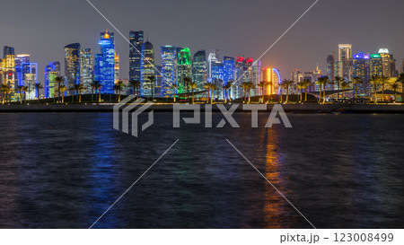 Doha city business downtown center panorama illuminated at night, with modern skyscrapers, promenade street with palms and sea in the foreground, Qatar Doha city business downtown center panorama illuminated at night, with modern skyscrapers, promenade street with palms and sea in the foreground, Qatar 123008499
