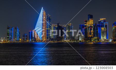 Doha city business downtown center panorama illuminated at night, with modern skyscrapers and sea in the foreground, Qatar 123008503