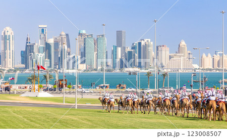 Royal camel guards parade against Doha futuristic business downtown center skyline with sea gulf in between, Qatar 123008507