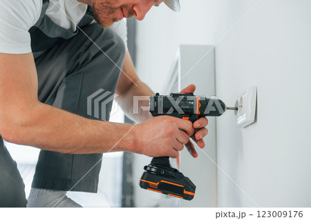Close up view. Repairman is working indoors in the modern room 123009176