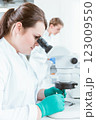 Female scientist using microscope in lab 123009550