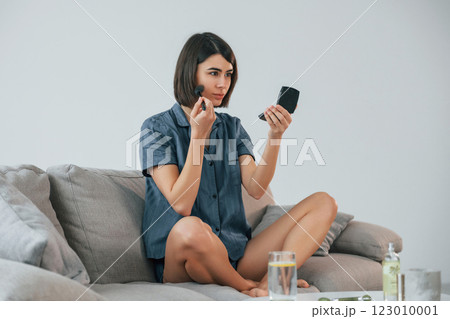 Using face make up. Powder product. Young woman is at home. Conception of beauty 123010001