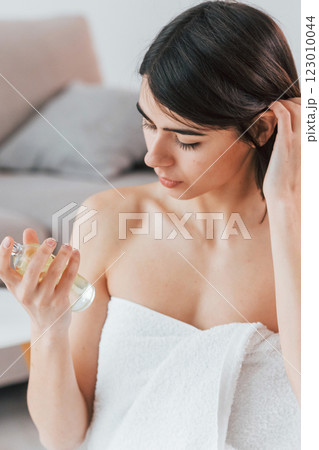 Trying new parfume. Young woman is at home. Conception of beauty Trying new parfume. Young woman is at home. Conception of beauty 123010044