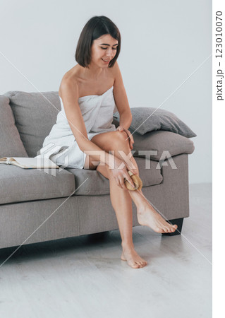 Cleaning legs skin. Young woman is at home. Conception of beauty Cleaning legs skin. Young woman is at home. Conception of beauty 123010070