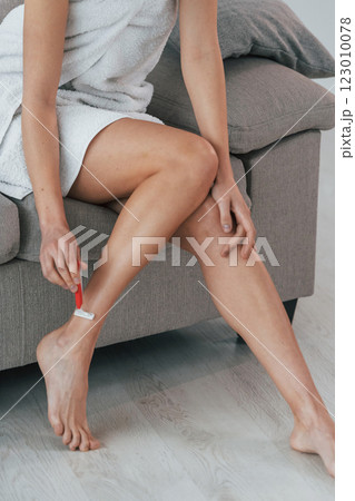 Shawing legs. Young woman is at home. Conception of beauty 123010078