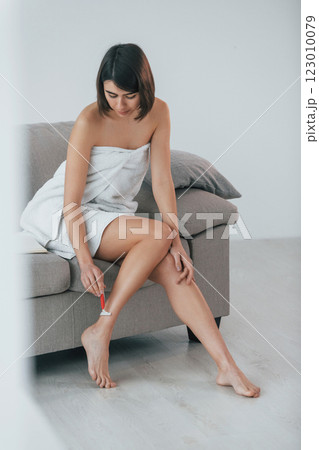 Shawing legs. Young woman is at home. Conception of beauty 123010079