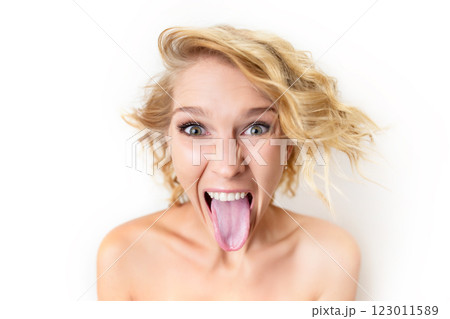 Closeup portrait of young caucasian woman with disgusted face expression isolated at white background. Irritated girl is showing grimace lolling out. Closeup portrait of young caucasian woman with disgusted face expression isolated at white background. Irritated girl is showing grimace lolling out. 123011589