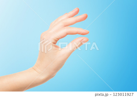 Closeup female hand making picking gesture isolated at blue background. 123011927
