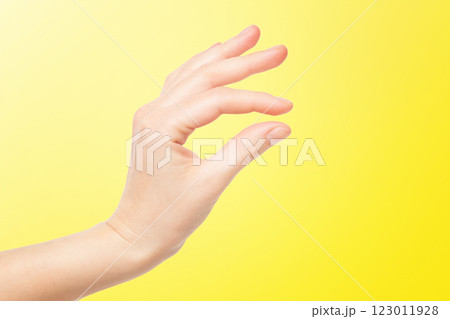 Closeup female hand making picking gesture isolated at yellow background. Closeup female hand making picking gesture isolated at yellow background. 123011928