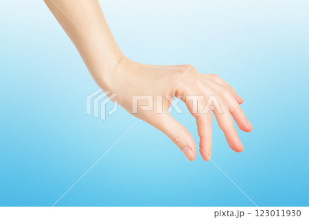Closeup female hand making picking gesture isolated at blue background. Closeup female hand making picking gesture isolated at blue background. 123011930