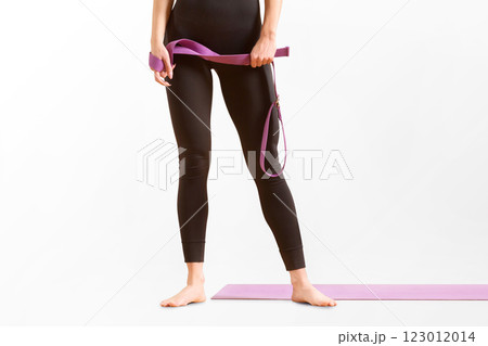 Slim athlete woman is holding trx straps for fitness training at isolated white background. 123012014
