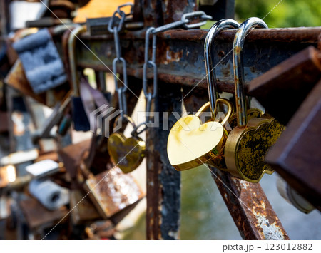 Golden heart-shaped padlocks symbolizing eternal love on a bridge 123012882