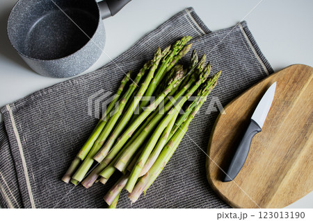 Preparing raw asparagus for cooking at the kitchen Preparing raw asparagus for cooking at the kitchen 123013190