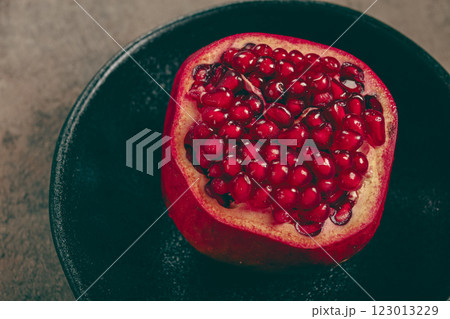 sliced fresh pomegranate, on a black plate, top view, rustic style, no people, sliced fresh pomegranate, on a black plate, top view, rustic style, no people, 123013229