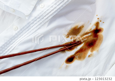 White shirt stained with soy sauce and chopsticks lying on it, no people, close-up , selective focus, 123013232
