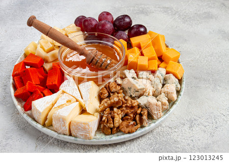 Appetizer, assorted cheese, with nuts and honey, on a round plate, top view, no people, Appetizer, assorted cheese, with nuts and honey, on a round plate, top view, no people, 123013245