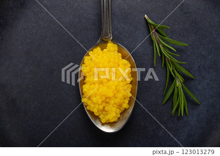 pearl yuzu, yuzu caviar - pearl, on a spoon, top view, on a dark gray plate, there are no people. 123013279