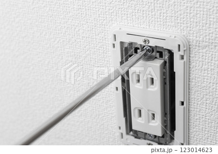 カバーを外したコンセントとプラスドライバー 123014623