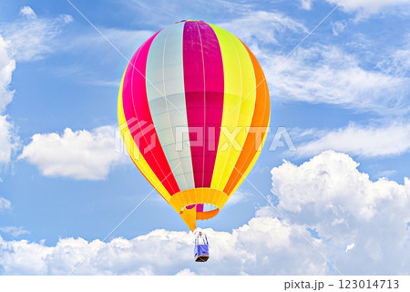 Colorful hot air balloon flying over blue sky with white clouds 123014713