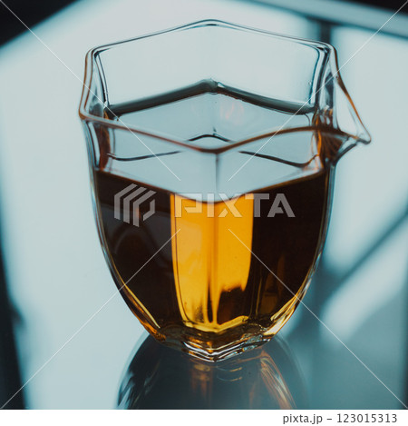 A stylish glass pitcher filled with vibrant amber liquid that stands out beautifully 123015313