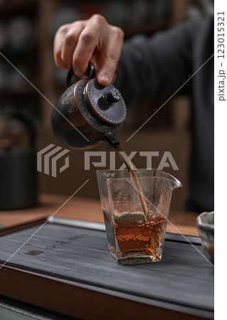 The Artisan Tea Pouring Process Unfolds in a Cozy Setting, Enriching the Experience 123015321