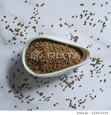 A CloseUp View of Fenugreek Seeds Placed Atop a White Dish on a Marble Surface Background A CloseUp View of Fenugreek Seeds Placed Atop a White Dish on a Marble Surface Background 123015334