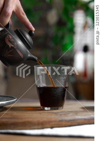 This is an Elegant Tea Pouring from a Stylish Teapot, creating a delightful moment 123015345