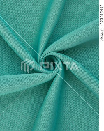 Close-up of twisted sea green curtain fabric texture in smooth folds 123015496