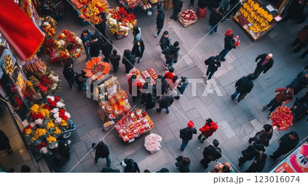 Aerial view of a bustling Asian street market with crowds of people shopping for flowers and food. 123016074
